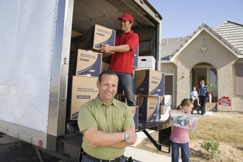 Professional movers carrying furniture on a local Barnescray street